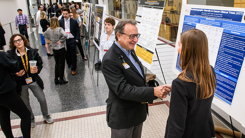 Dean Zweig reviewing a student's poster at Health Sciences Research Day