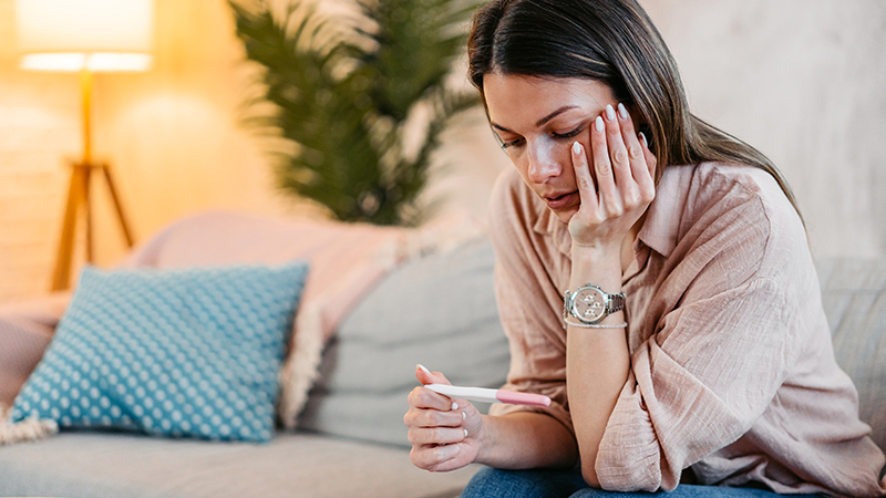 woman looking at pregnancy test