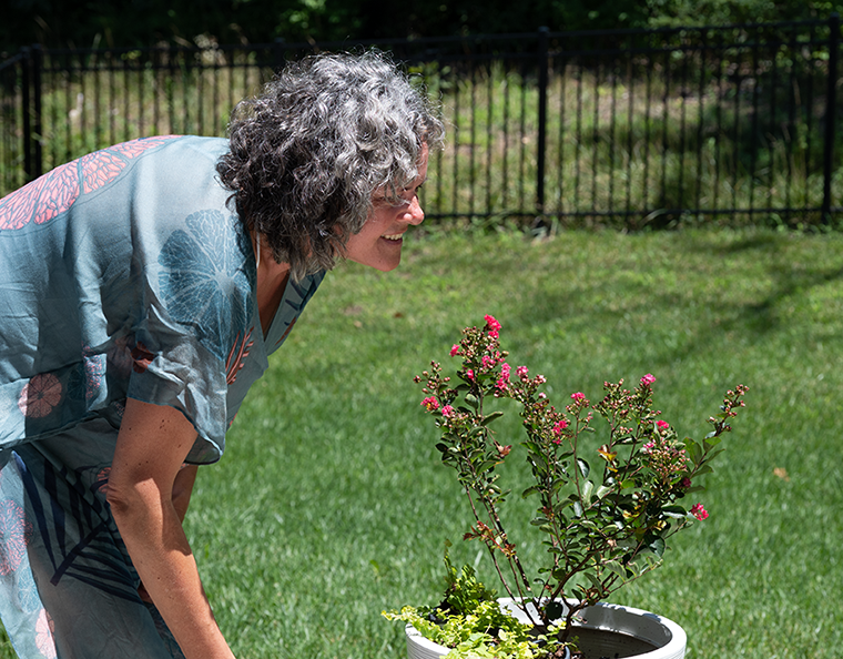 Bettina Mittendorfer, PhD, trims a few leaves off a flowering bush in her new home