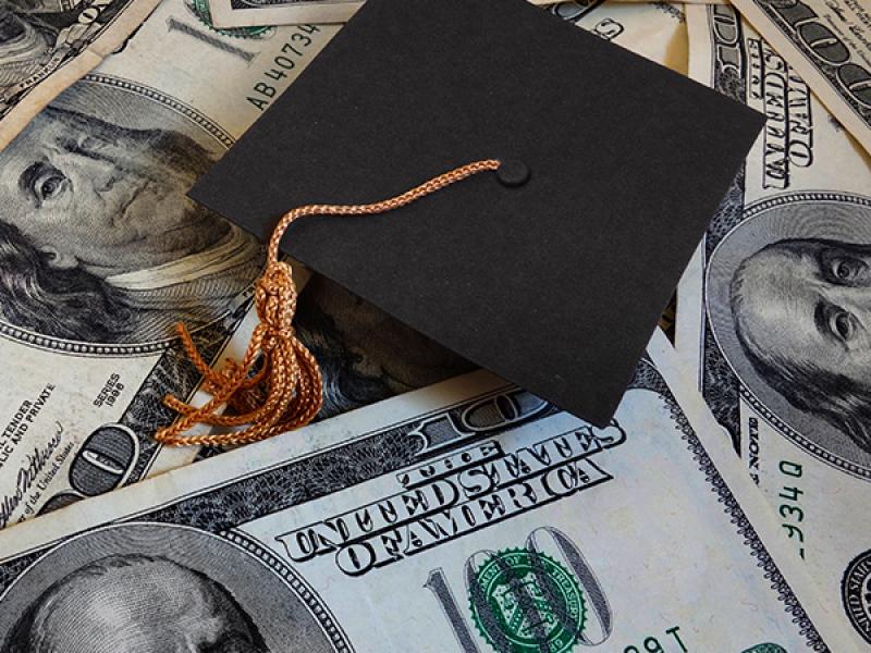 Photo of graduation cap and money.