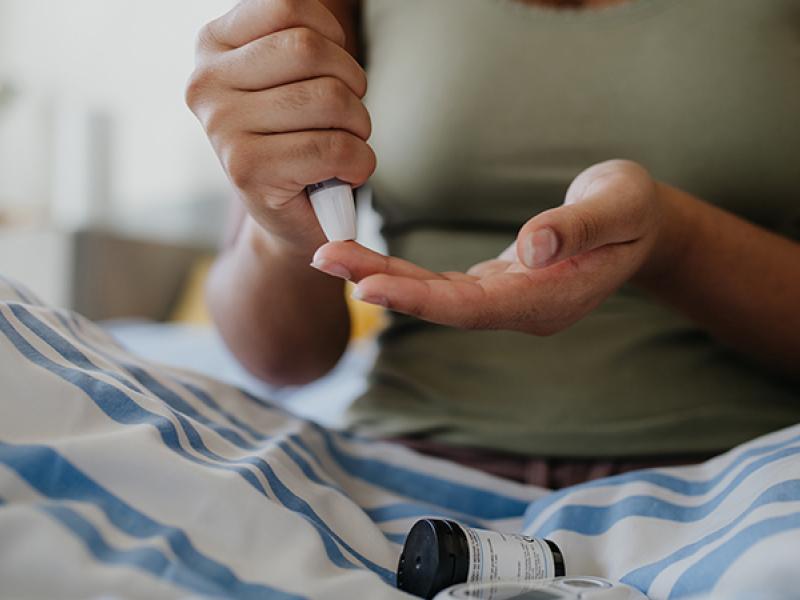 female doing a fingerstick blood test