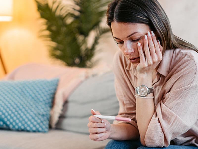 woman lookin at a pregnancy test